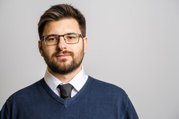 Portrait of one adult caucasian man 30 years old with beard and eyeglasses looking to the camera in...