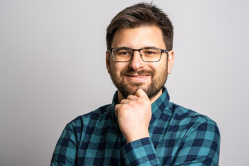 Portrait of one adult caucasian man 30 years old with beard and eyeglasses looking to the camera in...