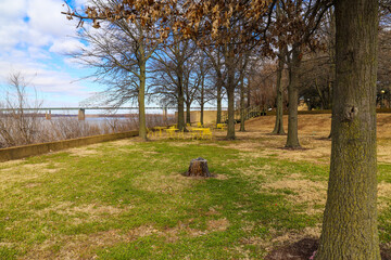 a shot of yellow metal tables and chairs surrounded by autumn colored trees and green and yellow...