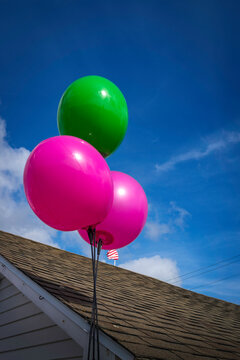 Pink and green Bloons over the rooftop