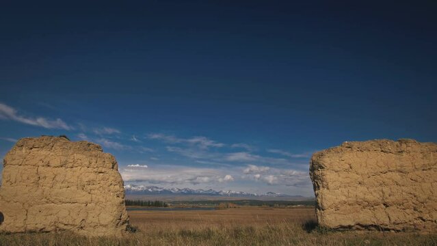 The man travel on mixed terrain cycle touring with bikepacking. The traveler journey with bicycle bags. Sport bikepacking, bike, sportswear in green black colors. Mountain snow capped, stone arch.
