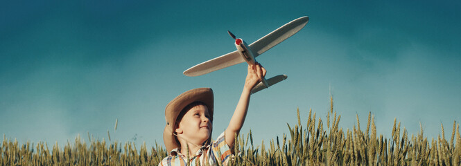 Happy kid playing with toy plane outside - success concept - 486978261