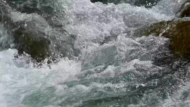 Slow motion of Norwegian mountain river , stream flowing through rocks. Close up of river stones with flowing water, clean water flowing in a mountain river at the Norway