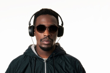 Young handsome African American man listening to music with headphones and wearing sunglasses. Man...