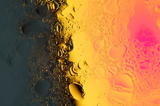 Creative bold colors background made of oil and water mix on glass surface with graduated warm colors lights. Vivid colors background.