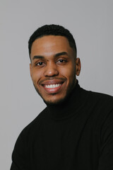 Fototapeta premium Portrait of millennial African American man posing over white wall. Vertical.