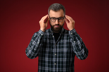 Portrait of a cool man with a beard, holding glasses with two hands