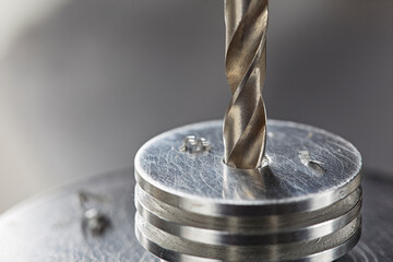 metal drill bit make holes in aluminium radiator on industrial drilling machine. Metal work...