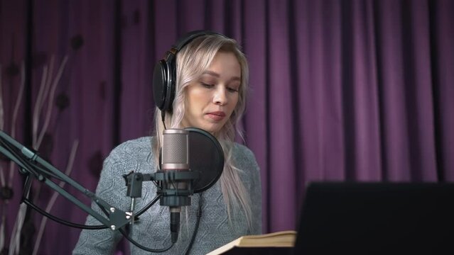 A blogger girl reads an excerpt from a book for her viewers live. The blonde leads a stream on the topic of poetry and fiction. Evening reading of an interesting book by a great writer.
