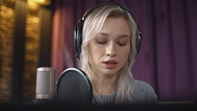 Portrait of a blonde blogger who reads an excerpt from a book for her viewers live.