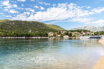Fototapeta premium bay in Ploce in Croatia, summer day in a holiday resort in Croatia, clear water, boats in ploce harbor, green hills in the mediterranean part of Croatia, Dalmatia