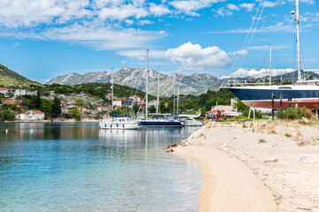 bay in Ploce in Croatia, summer day in a holiday resort in Croatia, clear water, boats in ploce harbor, green hills in the mediterranean part of Croatia, Dalmatia - obrazy, fototapety, plakaty