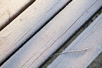A frost pattern on a park bench on a winter morning