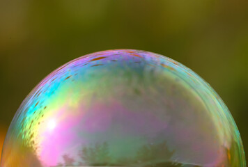 Soap bubbles creating colorful colors on the background of a park flower field