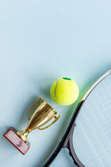 Small golden trophy cup with tennis racket and ball. Sport champion winner concept