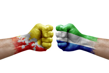 Two hands punch to each others on white background. Country flags painted fists, conflict crisis concept between bhutan and sierra leone