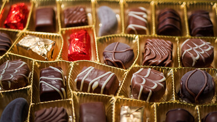 Delicious chocolate candies in packaging background