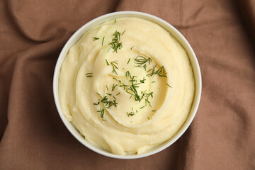 Freshly cooked homemade mashed potatoes on brown fabric, top view