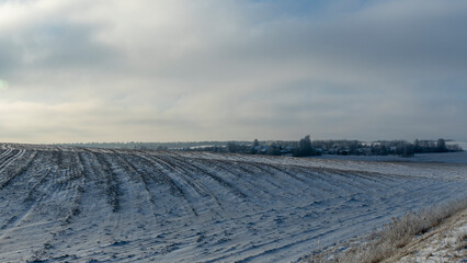 Winter farmland scenery landscape under snow with trees on background. Winter landscape with snow...