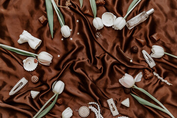 Flat lay women's fashion accessories, white tulips and candles.  Creative composition for fashion blog, web, social media. Top view