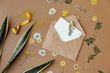 Spring or wedding or birthday mock up scene. Blank open sheet of paper and flowers with place for text for greeting card copy space. Flat lay, top view