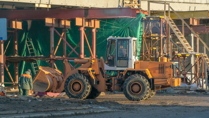 Motor grader on road construction. Orange bulldozer on bridge road construction site. Detour. Road Closed.