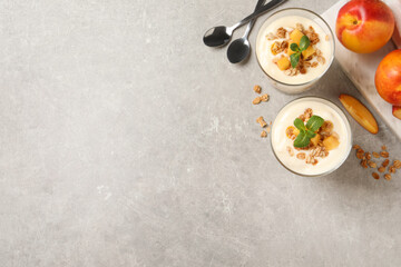Flat lay composition with tasty peach yogurt on light grey table. Space for text