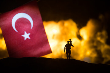 Turkey small flag on burning dark background. Concept of crisis of war and political conflicts...