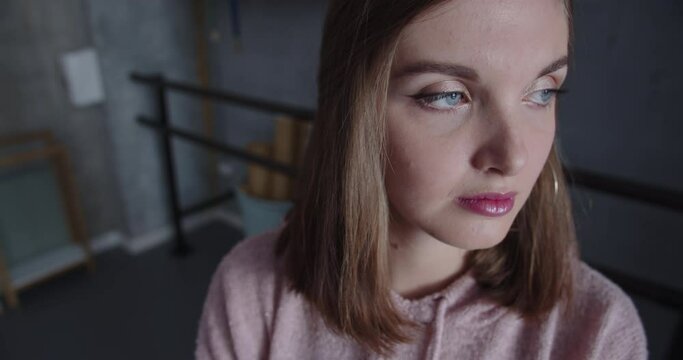Close up portrait of a beautiful sad young blue-eyed girl looking thoughtfully into the distance