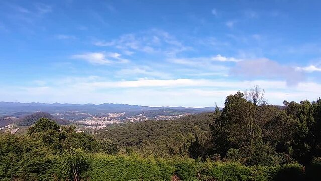 mountain range view with bright blue sky and city nestled at foothills video taken at ooty tamilnadu india.