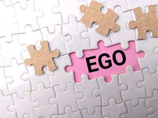 Obraz premium Top view white puzzle with text EGO on puzzle background.