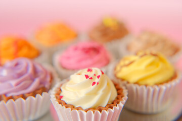 Cream dessert. Cream cupcakes.cakes on a pink background.Assorted sweet table. Sweets and desserts....