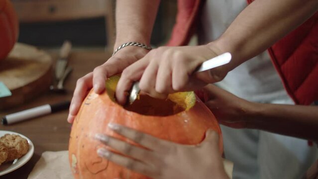 A handsome young lady is carving the pumpkin