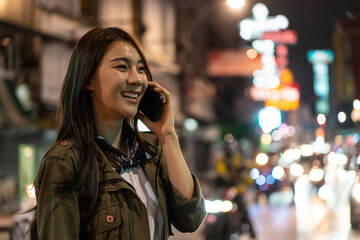 Asian attractive woman backpacker talking on mobile phone walk in city. 