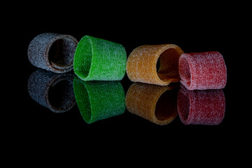 A closeup of different sour candy strips isolated on a black background