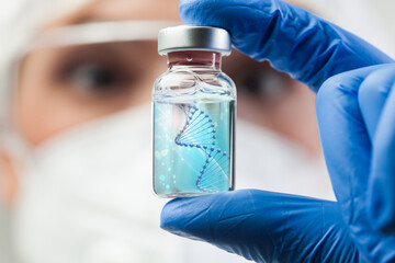 UK lab scientist biotechnologist holding glass ampoule vial with DNA strand - obrazy, fototapety, plakaty