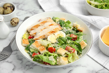Fototapeta na wymiar Delicious Caesar salad in bowl on white marble table