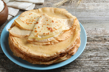 Stack of delicious crepes on wooden table