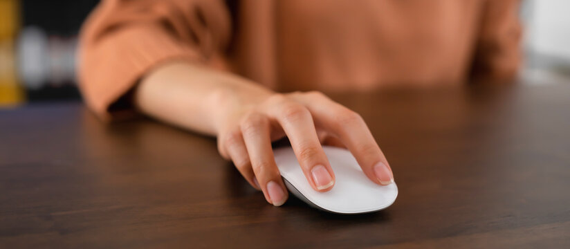 Close up of hand press the button computer mouse on table.