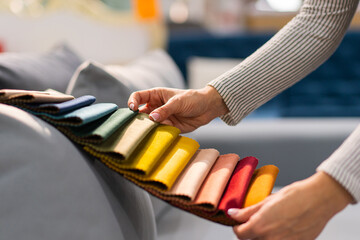 The woman chooses the fabric on the sofa. A young women looks at tissue samples. Selects the color...