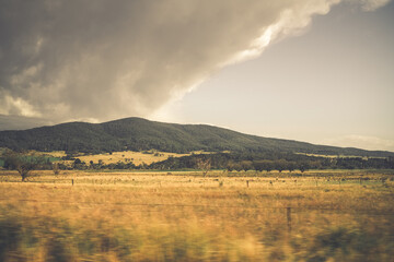 Fototapeta premium Mountains behind fields of golden grass