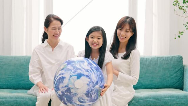 地球の模様のボールを見る三世代家族　環境イメージ　SDGs