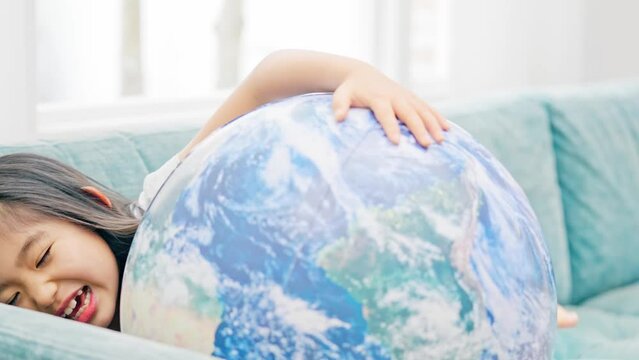 地球模様のボールで遊ぶ女の子　エコロジーイメージ　SDGs
