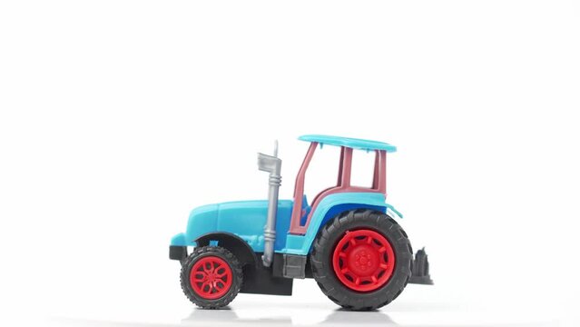 Blue tractor toy rotates on white background