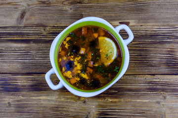 Russian traditional hodgepodge soup on a wooden table. Top view