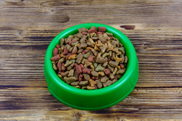 Bowl with pet food on a wooden background