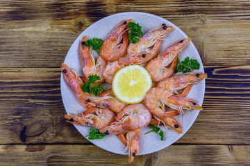 Shrimps with lemon and parsley on a plate. Top view