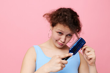 teenager girl removes hair on a comb dissatisfaction close-up unaltered