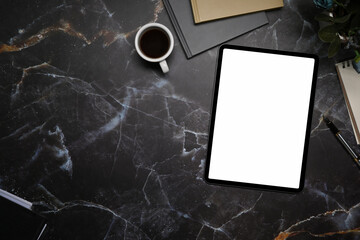 Digital tablet with empty screen, coffee cup and books on marble background.