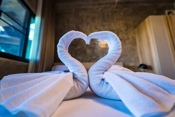 Fototapeta na wymiar Swans made of towels at the hotel.Love concept honeymoon bed for home or hotel bedroom decoration.